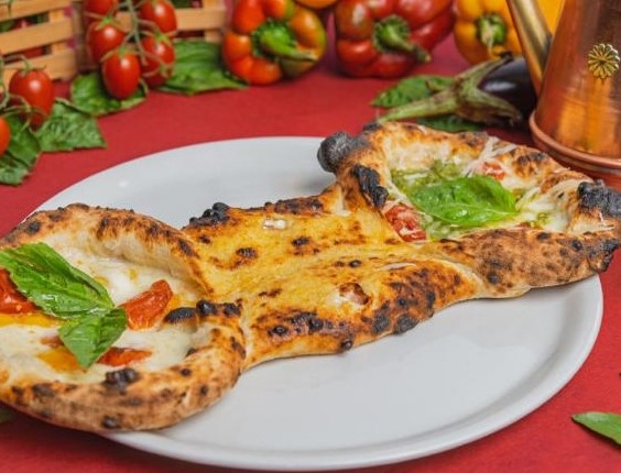 pizza Re Carmine, a forma di papillon, un lato con pomodirno del piennolo del vesuvio, pomodorini gialli e mozzarella fiordilatte, l'altro lato con piennolo, fiordilatte, pesto, scaglie di grana e centro ripieno con ciccioli e ricotta