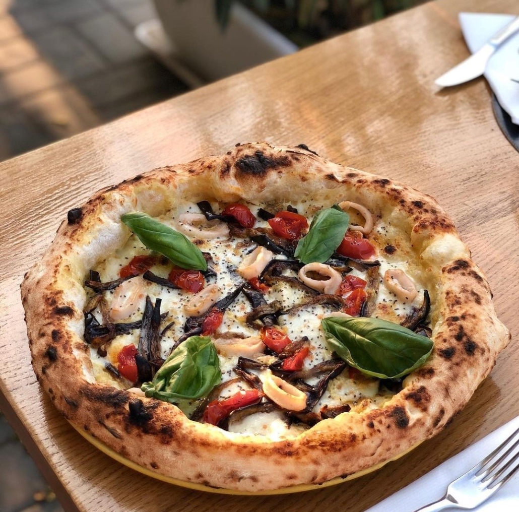 Pizza Mari e Monti, crema di melanzane homemade, pomodori caramellati, melanzane, seppie al limone, semi di chia, basilico ed olio evo